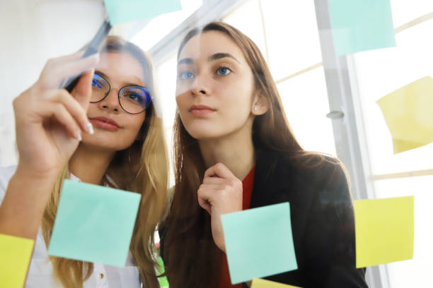 istock Two businesswomen looking at sticky notes 1199294918