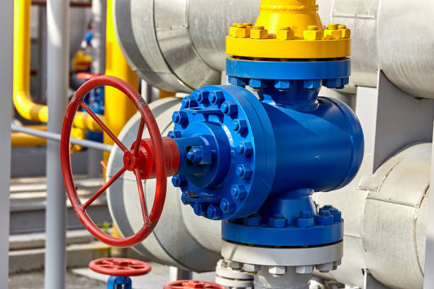 istock Blue valve on a yellow pipe at a gas processing plant 1199295184