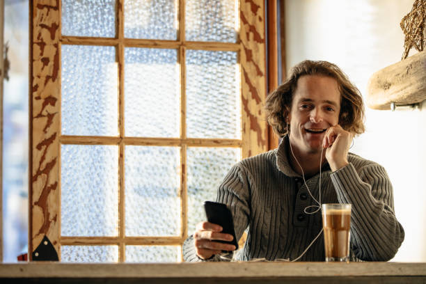 istock Young Redhead Man Talking On Mobile In A Coffee Shop 1199296618