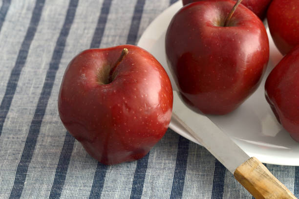 istock Delicious Apples in plate with knife on striped tablecloth 1199297529