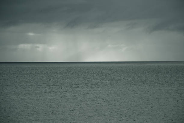 A grayish Indian Ocean with light on the horizon. In order to emphasize the beauty of the light, it was toned in monotone.