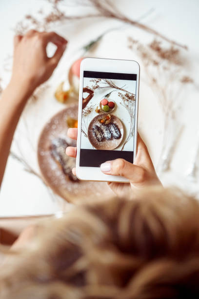 giovane vlogger adulto che fa foto di cibo su smartphone moderno - dessert cake elegance food foto e immagini stock