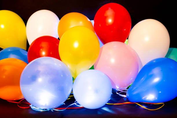 globos coloridos iluminados con led sobre fondo oscuro - balloon pink black anniversary fotografías e imágenes de stock