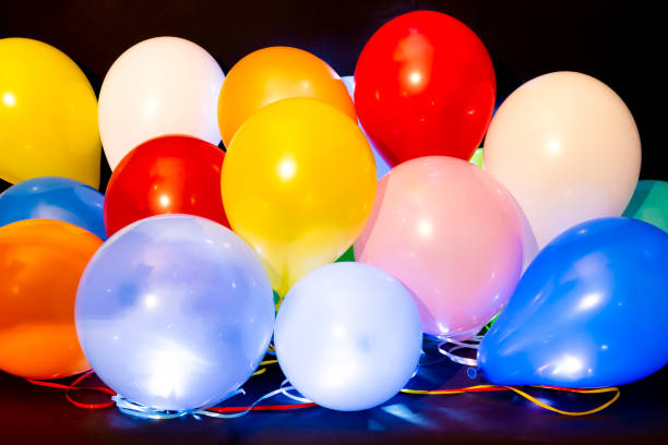 Colorful balloons illuminated with LED against dark background