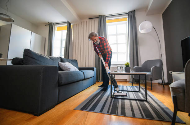 istock Senior Man Vacuum Cleaning at Home 1199307258