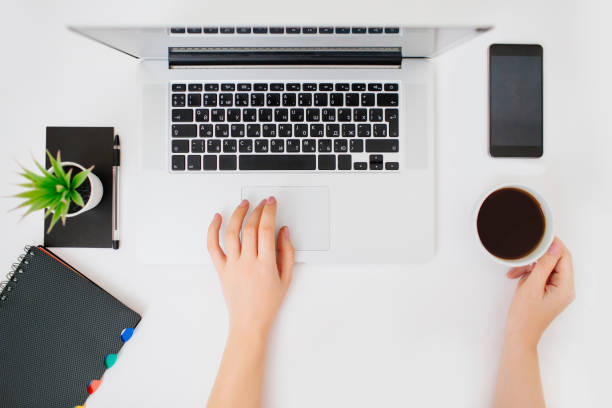 istock Flatlay with hands typing on a keyboard of laptop. White desk. 1199308486