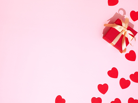 Valentine's Day background. Gift box and hearts on pink backdrop.