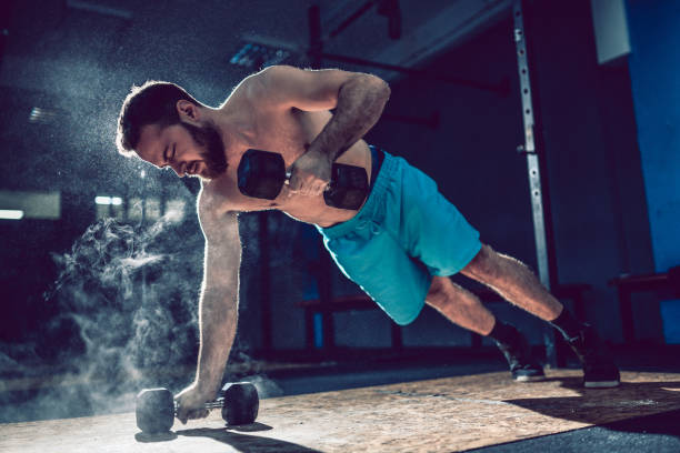 istock Male Athlete Working Out With Dumbbells In Gym 1199308743