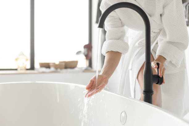 accendere l'acqua della vasca da bagno a casa - relaxation women bathtub bathroom foto e immagini stock