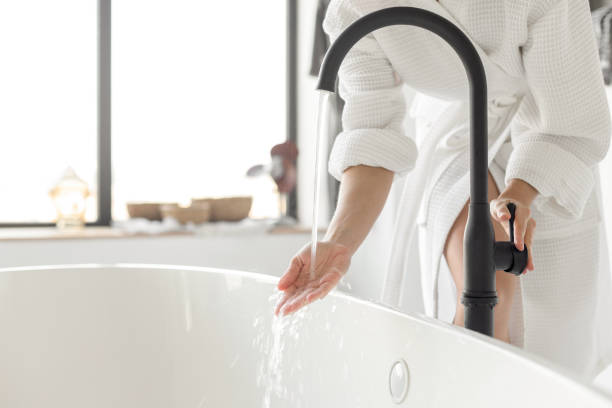 ligar a água da banheira em casa - bathtub women relaxation bathroom - fotografias e filmes do acervo