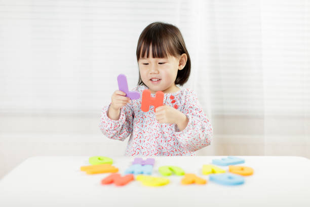 istock toddler girl learning alphabet letter at home against white background 1199312708