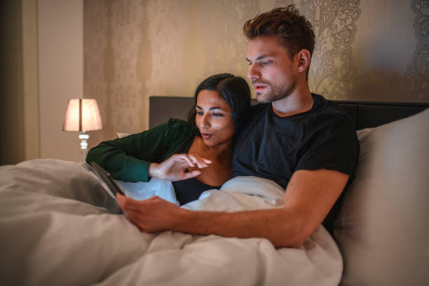 istock Young Couple Using Digital Tablet In Bed At Home 1199319157