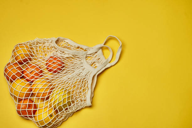 istock Replacing plastic bags. Taking care of the environment. Grid with fruit on colored paper, fortification. Minimalism 1199319873