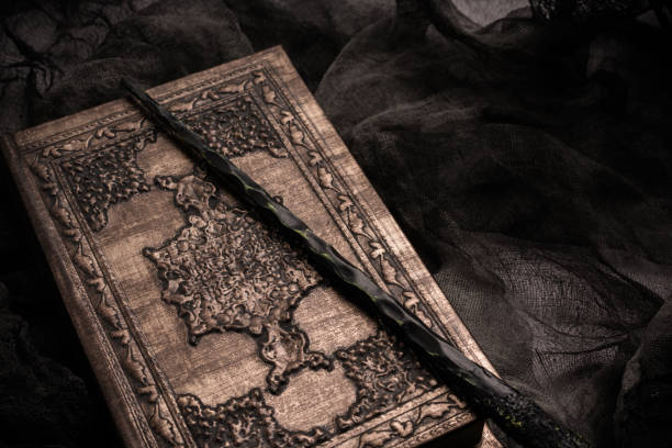 istock Old book with spells and magic wand on gray background with witch rag. Copy space for text 1199320196