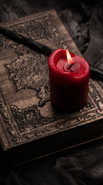 istock Old book with spells, red candle and magic wand on gray background with witch rag. Copy space for text 1199321663