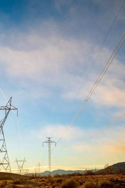 istock electrical power lines and towers in desert valley with snowy mountain range 1199322959
