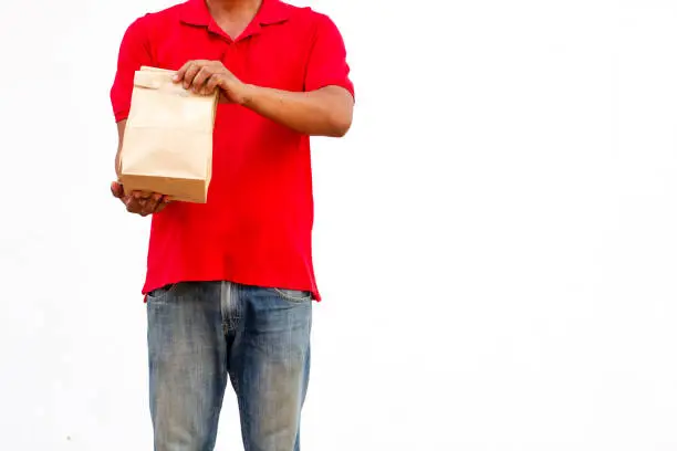 Photo of Holding various take-out food containers in holder and paper bag, close-up. Light grey background, place to insert your text. Delivery man.