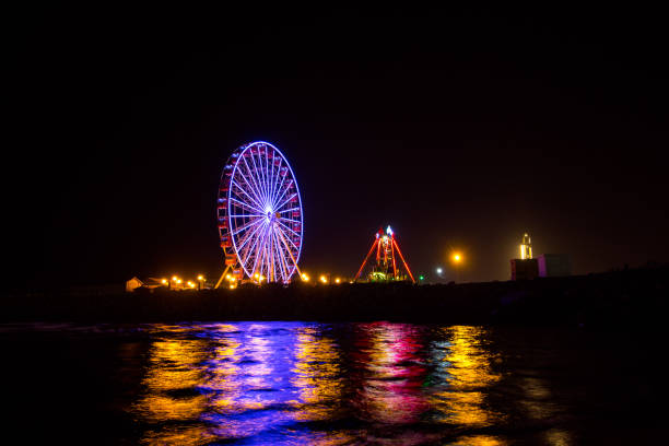 istock Ferris wheel in motion at amusement park at night 1199328319