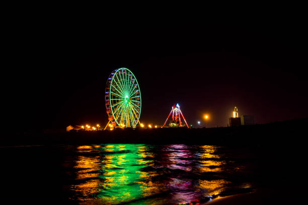 istock Ferris wheel in motion at amusement park at night 1199328551