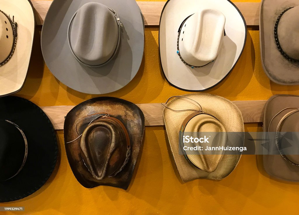 Vintage Cowboy Hats Hanging, Vibrant Yellow Background Texas Stock Photo