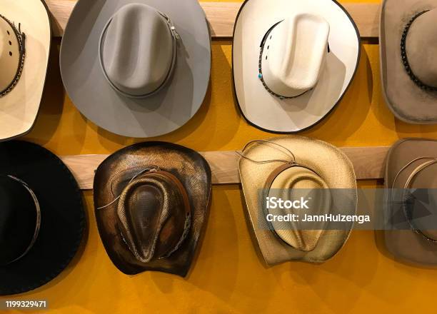 Vintage Cowboy Hats Hanging Vibrant Yellow Background Stock Photo - Download Image Now
