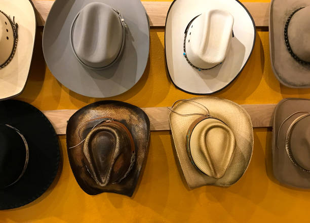 vintage cowboy hats hanging, vibrant yellow background - southern charm imagens e fotografias de stock