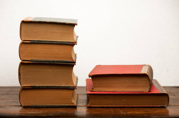 istock stack of old books on wooden table with white background 1199331306