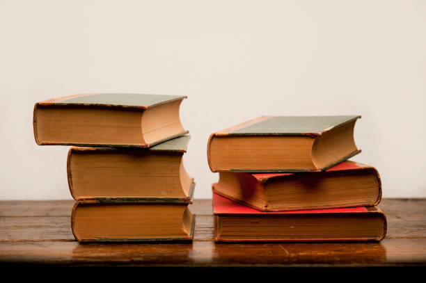 istock stack of old books on wooden table with white background 1199331359