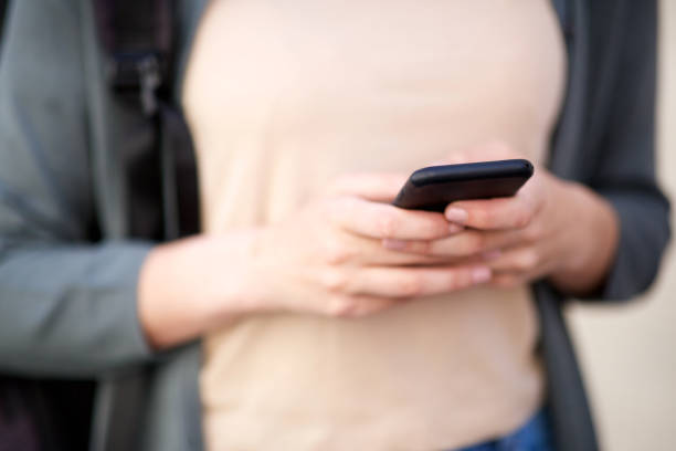 istock Close up female hands holding cellphone 1199331587