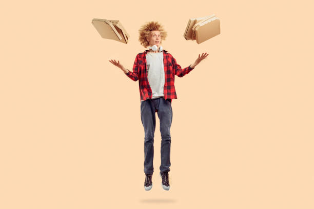 Young man jumping up with carton pizza boxes