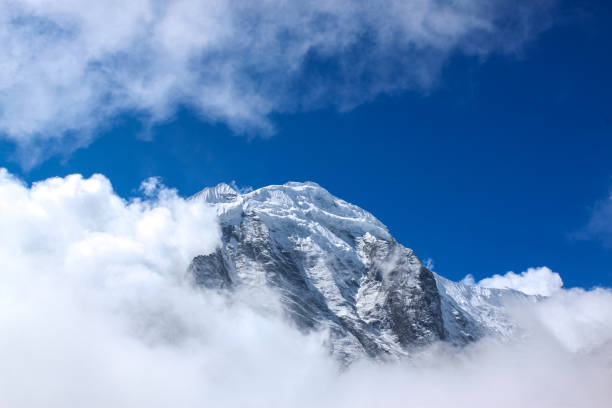 istock Top of the hill, covered with snow and white clouds 1199332663