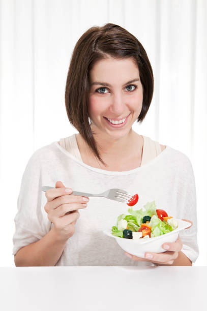 istock young woman eating salad 119933517