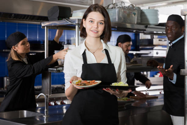 istock Waitress holding meals in restaurant kitchen 1199336304