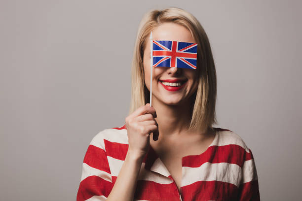 istock girl holds British flag on gray background 1199337748