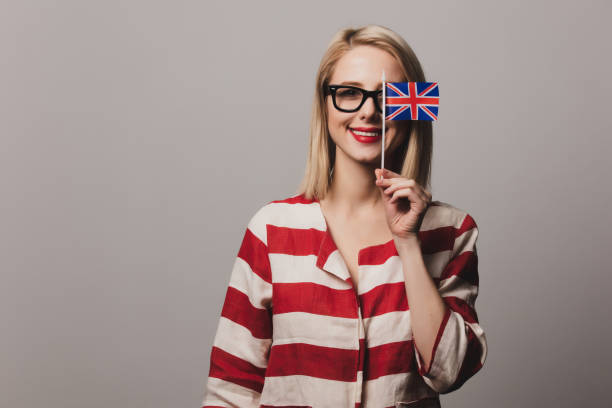 istock girl holds British flag on gray background 1199337798