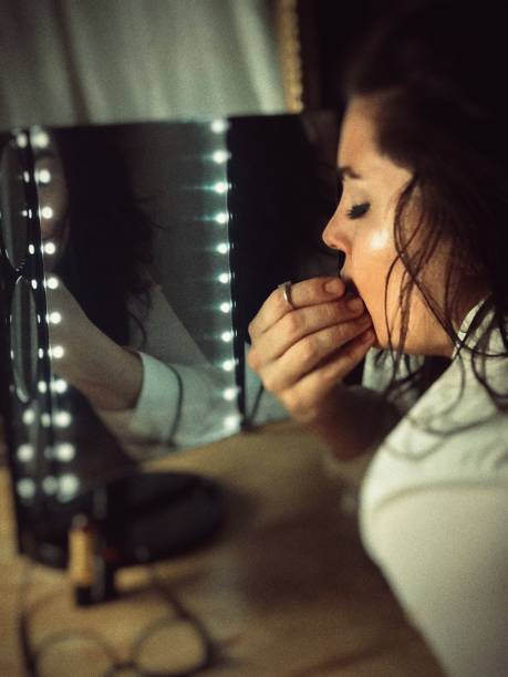 istock Lighted mirror and reflections of a beautiful woman. 1199343572
