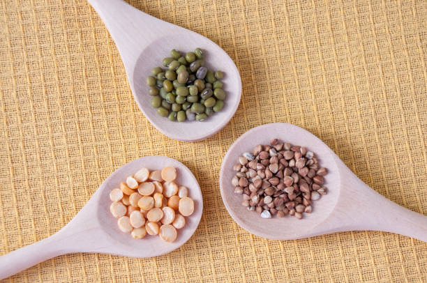 istock Three wooden spoons with buckwheat, mash and peas on the table, top view 1199343804