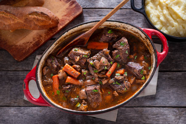 Beef Bourguignon Beef Bourguignon in an Enameled Cast Iron Dutch Oven beef stew stock pictures, royalty-free photos & images