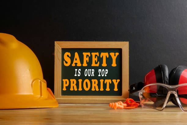 la seguridad es nuestro concepto prioritario. equipo de protección personal sobre mesa de madera sobre fondo negro. - near miss” fotografías e imágenes de stock