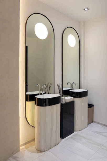 istock Modern interior of a public bathroom with basins mirror and faucets. 1199344840