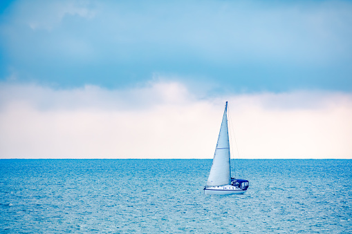 Sailing yacht in the blue calm sea. A yacht in peaceful waters.