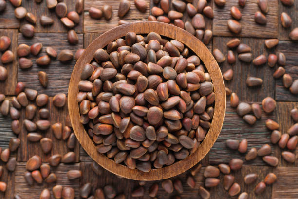 istock shelled pine nuts in wooden bowl, top view. 1199348873