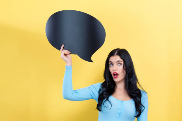 istock Young woman holding a speech bubble 1199352771