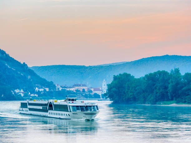 The Austrian region of the Danube River Valley on May 27, 2018: View of the Danube River with the town of Durnstein and a passing river cruise boat in Austria
