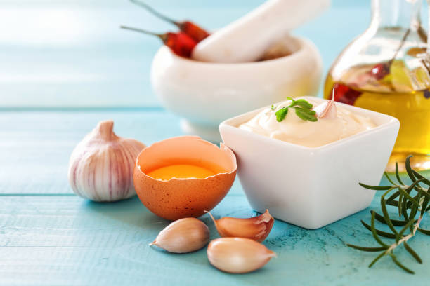 Garlic sauce Aioli on the blue wooden background. Selective focus.