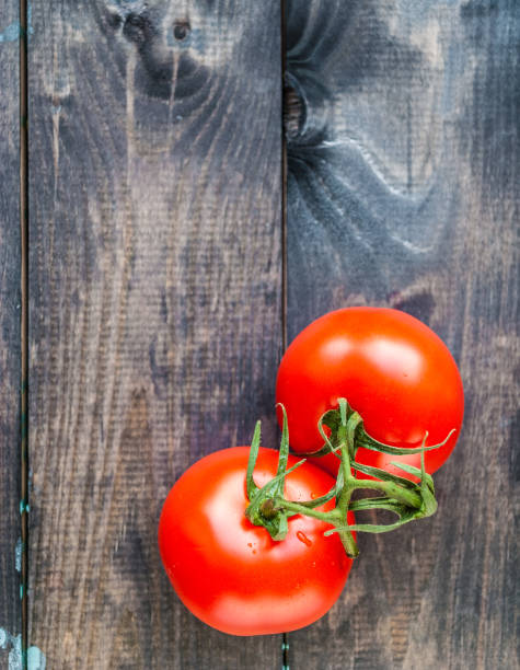 istock Fresh red ripe tomatoes on a branch on a wooden background 1199363070