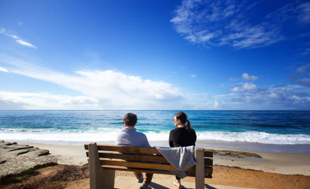 La Jolla, CA: A couple sitting on a bench admiring the Pacific Ocean in La Jolla.