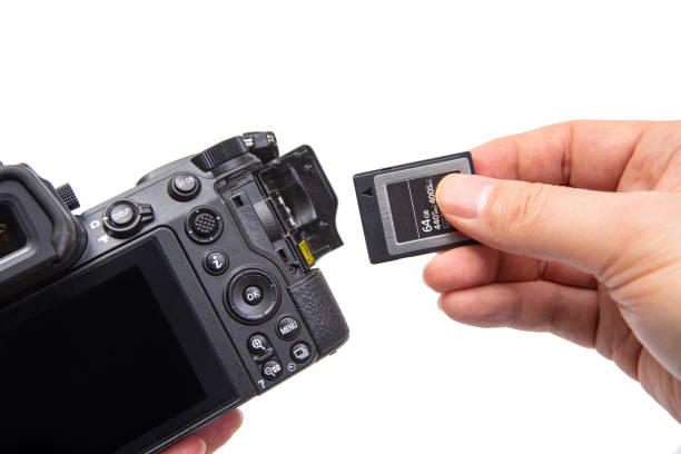 man's hand holding xqd memory card on a white background. - memory card imagens e fotografias de stock