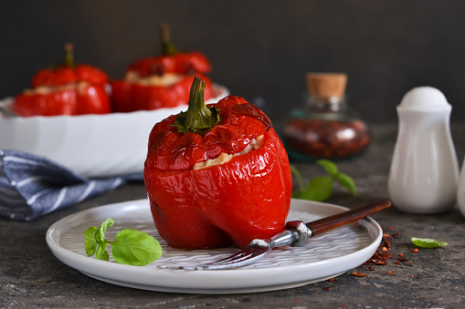 Baked stuffed peppers with meat and rice on a concrete background.