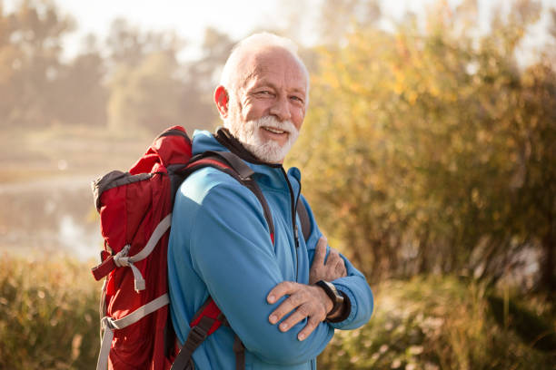istock Senior man on a footpath hiking posing with smile 1199376007